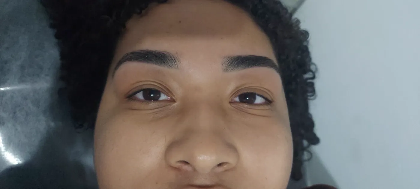 Cliente de olhos abertos, com as sobrancelhas desenhadas e preenchidas
